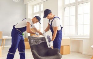 Two movers wrapping a chair