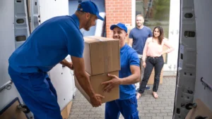 Movers loading boxes into a van during a home move