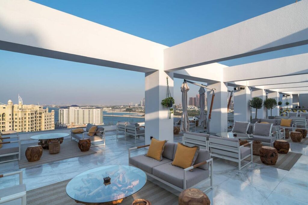 Modern rooftop terrace with white pergola and luxury outdoor seating overlooking the city