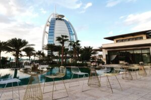 Outdoor luxury poolside seating with Burj Al Arab hotel in the background