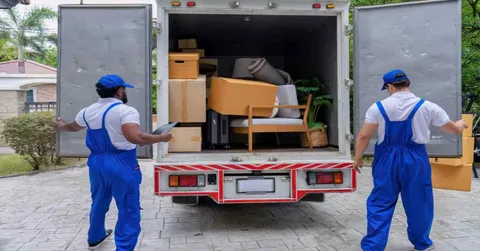 Movers unloading boxes and furniture from a moving truck