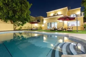 Luxury villa exterior in Dubai with swimming pool at night