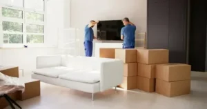 Movers installing TV and packing boxes in Downtown Dubai apartment