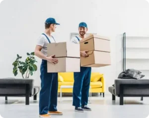 Two professional movers carrying cardboard boxes in a modern apartment.